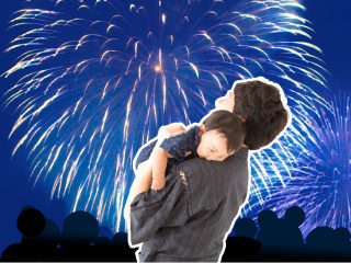 花火大会で赤ちゃんを抱っこする父親