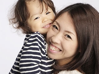 子供を抱きながら微笑む母親