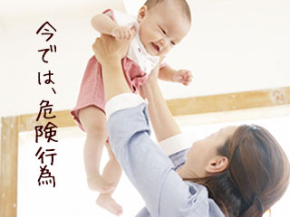 赤ちゃんを両手で高く持ち上げる母親