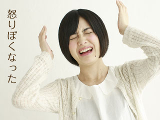 両手を挙げて顔を歪める女性