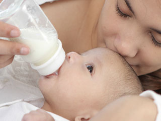 赤ちゃんにミルクを飲ませる母親