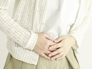 両手でお腹を押さえる女性