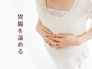 お腹に両手を乗せる女性