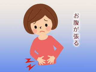 お腹を押さえる女性