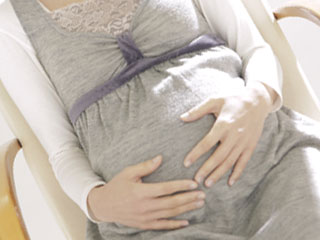 お腹に手を当てる妊婦