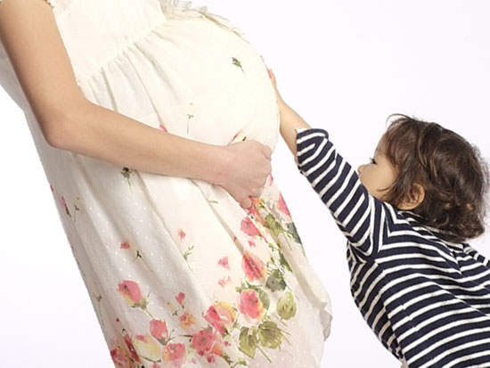 妊婦のお腹に触る子供