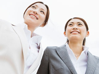 スーツを着た女性が二人並んでいる。