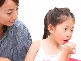 歯磨きする子供と見守る母親