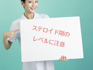看護師が注意喚起のパネルを持つ