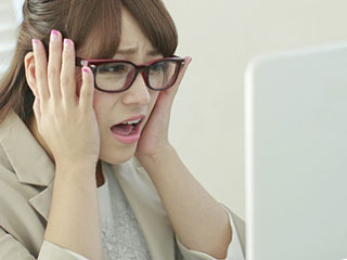 仕事しながら顔をしかめる女性