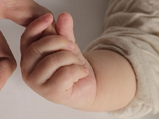 親の手を握る赤ちゃん