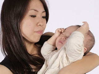 赤ちゃんを抱く母親