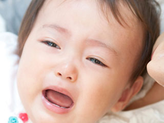泣き出しそうな顔の赤ちゃん