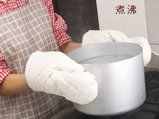 煮沸したお湯を持つ女性