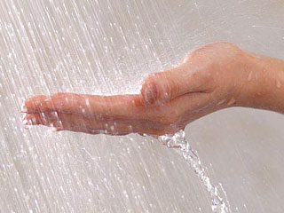 シャワーの水に手を差し出す
