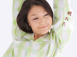 パジャマ姿で体を伸ばす女性