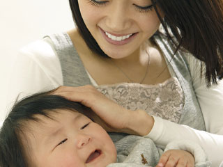 具合悪そうな子供をなでる母親