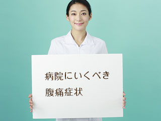 受診を促すパネルを持つ看護師