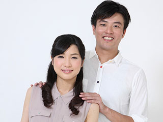 妻の肩に手を置く夫