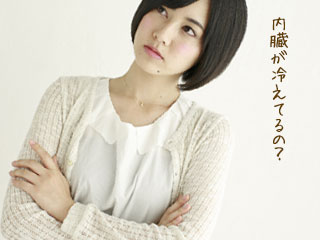 カーディガンを羽織って腕組みしている女性