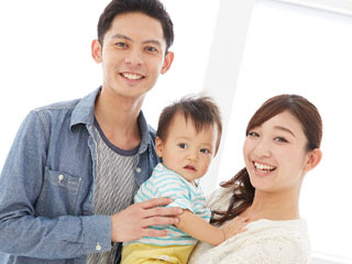 夫婦と子供三人が笑顔で並んでいる