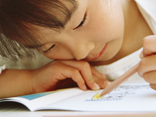 ノートに顔を近づけている子供