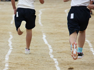 運動会で並んで走る小学生