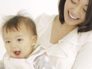 抱いた赤ちゃんを覗き込む母親