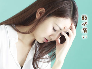 頭を押さえながら俯く女性