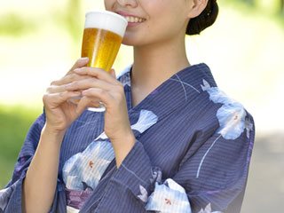グラスでビールを飲む女性