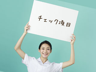 チェックのパネルを掲げる看護師