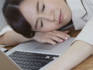 職場で仮眠する女性