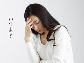 額を押さえながら俯く女性