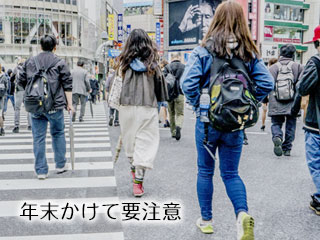 都会の交差点を歩く人々