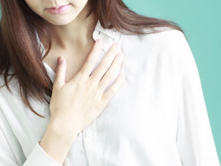 胸を押さえる女性