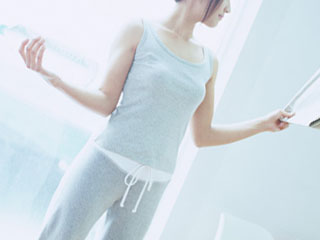 両手に物を持って直立姿勢の女性