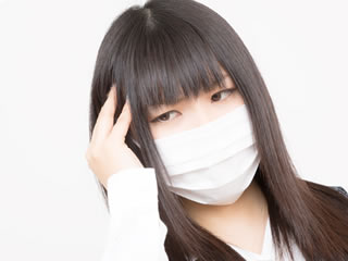風邪をひいてマスクをする働く母親