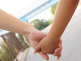 手を繋いで散歩する母親と子供