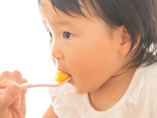 離乳食をスプーンから食べる赤ちゃん