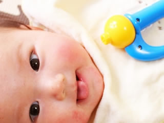 ツルツルお肌とおもちゃで機嫌が良い赤ちゃん