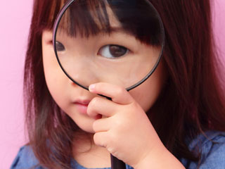 虫眼鏡を覗く子供