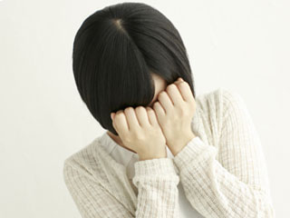 両手で顔を覆う女性