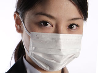 スーツ姿の女性がマスクをしている