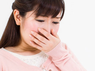 片手で口を押さえる女性