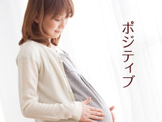 笑顔でお腹をさわる妊婦