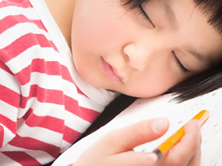 算数の勉強中に寝落ちする小学生
