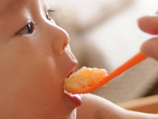 スプーンで食事する赤ちゃん