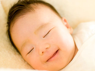 寝ながら微笑む赤ちゃん
