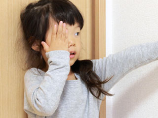 片目を手で隠す子供