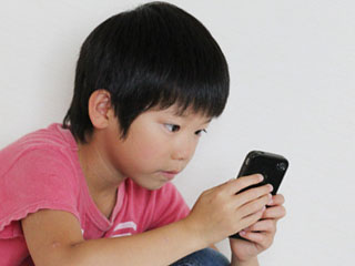 携帯ゲームをする子供